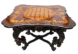 Table with marquetry top (as evidenced by cracking joints on left and right of top, but having wood grain carry on to both cleats indicating the surface is veneered) Mihailo Obrenović, Prince of Serbia.