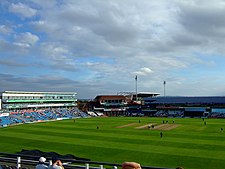 A panoramic view of a cricket ground with players occupying the field