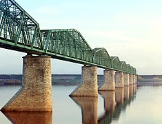 Kama River near Perm. The bridge still stands today, but another similar bridge has been built alongside it. Both are painted white.