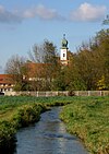 Blick auf Unterbiberg mit der Kirche St. Georg – im Vordergrund der Hachinger Bach