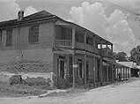 Street with two-story brick hotel and smaller wooden buildings