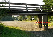Brücke über einen trocken gefallenen Gewässerarm mit roter und gelber Punktlinie, die den üblichen Wasserstand zwischen 1 und 1,2 Meter anzeigen
