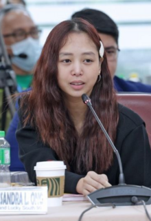 A woman seated in front of a microphone.