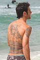 Man with tattoos on his back - at the beach