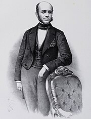 Engraving with a three-quarters length portrait of a balding, middle-aged man in formal dress leaning on the back of a Victorian-era armchair