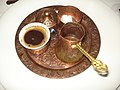 Turkish coffee set containing a cup of coffee, a cezve and a sugar bowl