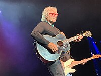 Musician Henry Paul playing an acoustic guitar.