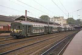 Von einer Elektrolokomotive geschobener Doppelstockzug unter Wechselspannungs-Oberleitung bei der Durchfahrt auf den Ferngleisen in Richtung Argenteuil (1982)