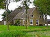 Kleine kop-hals-rompboerderij met zeer korte hals, voorhuis onder hoog zadeldak tussen topgevels en met riet gedekte schuur