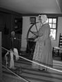 A woman demonstrates spinning wool into yarn