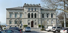 The front of the parliament building, white with several windows