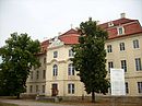 Schloss und Park des Schlosses Martinskirchen sowie Sächsischer und Preußischer Hof: Sächsischer Hof, bestehend aus Stallungen mit Pächterhaus im Norden, Fachwerkgebäude im Westen und Wohnhaus mit Mansarddach im Osten sowie Pflasterung des nördlich vorbei führenden Wegs; Preußischer Hof, mit landwirtschaftlichem Quergebäude, Ochsenstall und Kuhstall mit anschließendem Wohnhaus, erhaltenen Außenmauern der westlich anschließenden Kleintierställe und dem nach 1950 gebautem Wohnhaus sowie das zweigeschossige Wohnhaus an der Schlosszufahrt