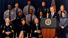 Photo of Senator Biden giving a speech, with uniformed law enforcement officers in the background