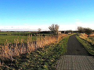 Foto die een gedeelte van het gebied vanaf de vroegere spoorwegbedding (het huidige fietspad op de voorgrond) toont dat in 1914 onder water werd gezet (26 dec 2004)