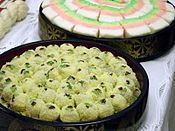 Bupyeon, with mujigae tteok at top. Bupyeon are doughs of glutinous rice flour and a sweet filling and covered with gomul (powdered beans).[8]