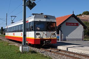 Red and white train next to a shelter on the platform