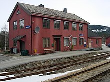 Foto eines Bahnhofsgebäudes mit roten Holzpanelen