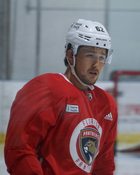 Ice hockey player in a red Florida Panthers practice jersey