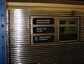 Gesickte Stahlseitenwand eines U-Bahn-Zugs, drei Rollbandfelder mit weißer Beschriftung auf schwarzem Grund: "Jamaica Center Parsons/Archer / World Trade Center / (E) Queens Blvd 8 Avenue
