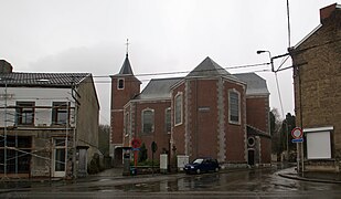 Religious building in brick in Neo-Romanesque style. On the left, a residence.