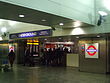 The interior of a building with people walking in various directions under a blue sign reading "HEATHROW TERMINALS 1, 2, 3 UNDERGROUND"