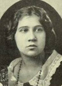 A young woman with dark wavy hair, from a yearbook photograph