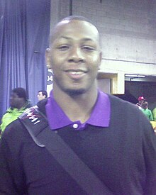 An American football player wearing a baby blue jersey with the number 81 across the chest and black cap on his head