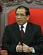 a man with greying black hair, wearing a suit and tie