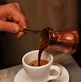 Copper cezve with Turkish coffee pouring out