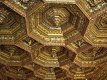 a renaissance wood ceiling gilded formed of octagons with a pendant in the center