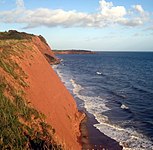 Kliff bei Orcombe Point (die sogenannten Orcombe Rocks) mit Blick nach Osten, über die Sandy Bay zu Straight Point (am Horizont).