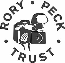 Logo. Rory Peck Trust in a circle around an illustrating of a cameraman.