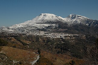 Blick von der Sierra de las Nieves über den Ort Yunquera auf die beiden ausnahmsweise schneebedeckten Gipfel des Pico Cabrilla (1506 m) und des Pico Prieta (1518 m)