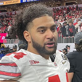 A football player talks on a football field.