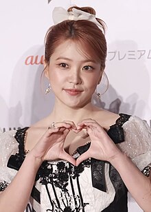 Yeri posing for photographers, holding up a heart sign with her hand at KCON in Japan.