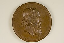 Das Foto zeigt die Vorderseite der bronzen Graefe-Medaille. In der Mitte ist Albert von Graefes Porträt im Profil mit Blick nach rechts erhaben geprägt. Es wird umrahmt mit dem in der oberen Hälfte am Rand in Versalien geprägten Namen „ALBRECHTVS • DE • GRAEFE“. Die untere Hälfte, abgesetzt von der oberen durch jeweils einem fünfzackigen Stern, zeigt die folgende Daten in römischer Ziffern „N • D • XXII • M • MAI • A • MDCCCXXVII • M • D • XX • M • IVL • A • MDCCCLXX“. Unterhalb des Halses befindet sich eine Signatur: „F. Hartzer FEC. E. Weigand SC“