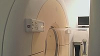 The circular containment tube separates the patient table in the "hot" zone (pathogen present) from the "cold" zone around this MRI machine.