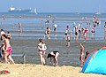 Niedrigwasser am Strand mit Watt, dahinter Jade-Fahrrinne nach Wilhelmshaven