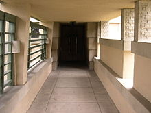 The entrance loggia on the north side of the house. There are metal grilles on the left and half-height partitions on the right.