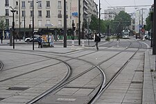 Gleisverzweigung auf dem Cours de Vincennes – die geraden Gleise führen als Betriebsstrecke zur Linie T3b, deren Zug (im Hintergrund) hat soeben die Endstation Porte de Vincennes verlassen