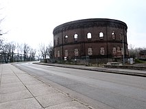 Gasometer am Holzplatz, links im Hintergrund die Genzmer-Brücke[18] über die Schiffersaale nach Glaucha, 2016