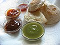 Vier ver­schieden­farbige Saucen, mit Samosas