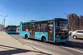 An LNG-powered Volgabus-4298.G4 of West-Service LLC departing from the bus stop. The orange stickers, placed on the doors, warn that cash is not accepted onboard of the bus