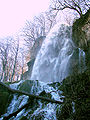 Der Uracher Wasserfall in einem Seitental der Erms in der Zeit der Schneeschmelze; das Wasser fällt 37 Meter frei in die Tiefe