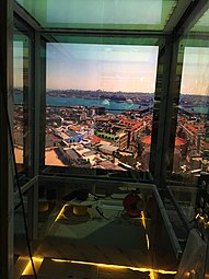 Asansörlerin kabin içi görünümü (duvarlar ve tavandaki ekranlarda, video duvar tekniği kapsamında oynatılan video yer alır)