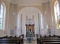 Blick in den Chorraum mit modernem Altar, Taufstein und neuer Kanzel