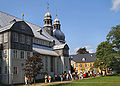 Kirche mit grauem Anstrich und bepflanztem Außengelände (2005)