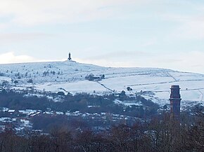 Winter outdoor scene, showing town in foreground with snowy moors with the tower on the horizon