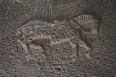 Large low-relief depiction on the interior side of the stone lintel above the entry.