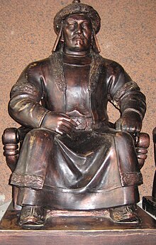 Statue of a robed man sitting; a plaque displays his title, Tsagaadai Khan.